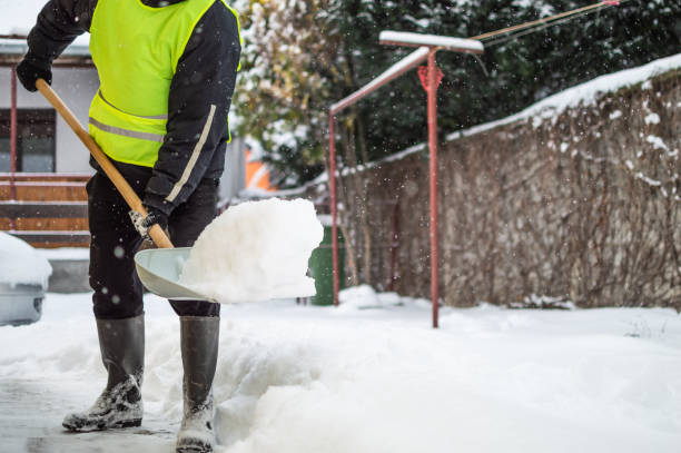 istock Man with snow shovel cleans sidewalk 1180584095