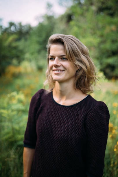 istock Smiling Young Woman Looking Away Against Trees 1180589582