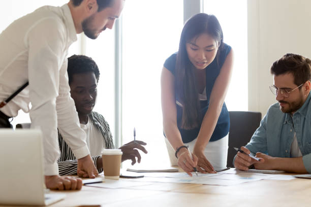 istock Focused diverse business team discuss paperwork at group office meeting 1180590187