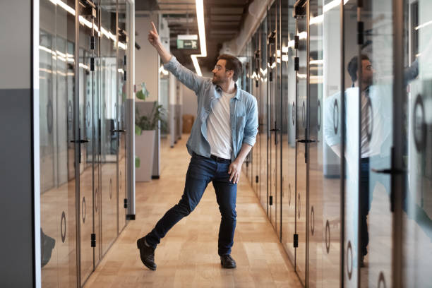istock Funny excited young businessman winner dancing alone in office hallway 1180590220