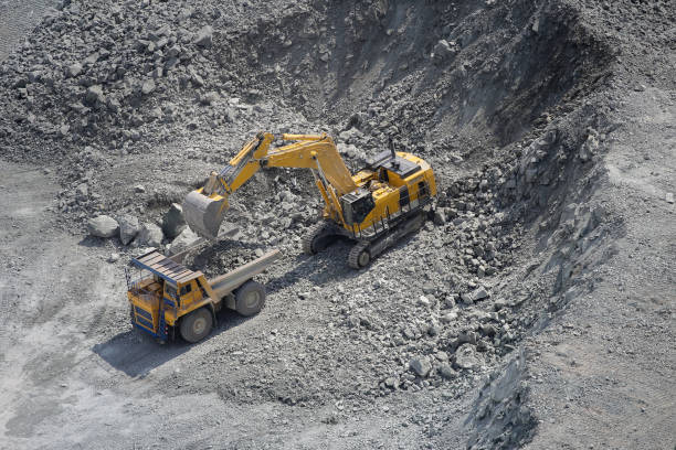 istock Excavator loads ore into a large mining dump truck. Top view 1180591478