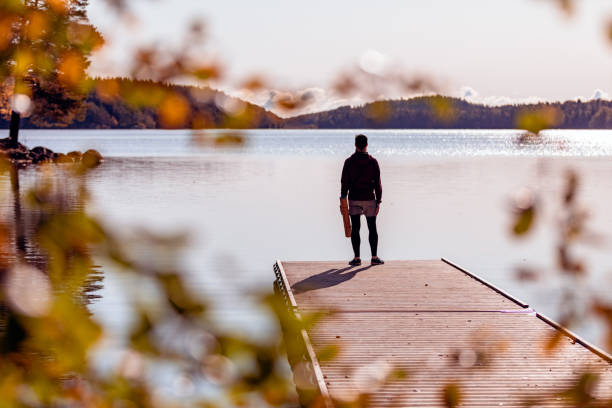 istock Man looking out over a lake 1180596419