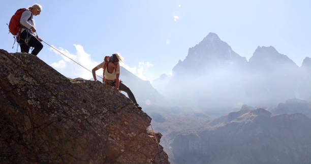 la mère assassine la fille tout en grimpant la crête de roche, utilisant la corde - climbing mountain climbing rock climbing women photos et images de collection