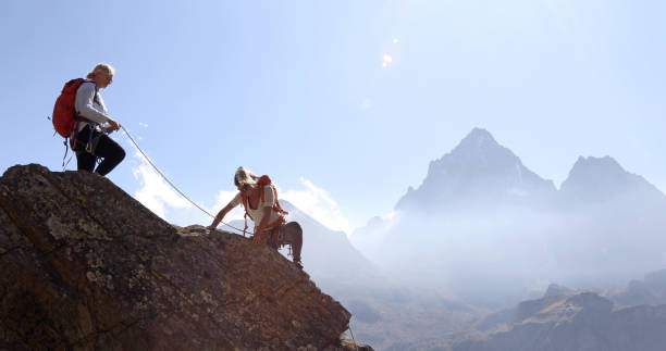 la mère assassine la fille tout en grimpant la crête de roche, utilisant la corde - mountain climbing rock climbing motivation awe photos et images de collection