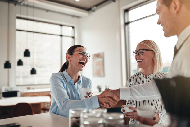 istock Laughing businesspeople shaking hands together during their coffee break 1180599419
