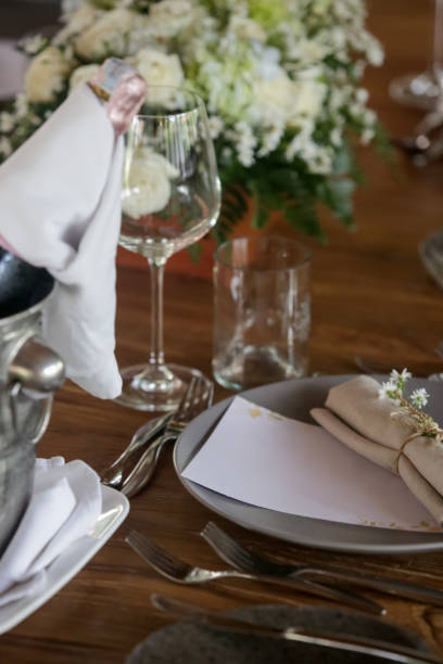 istock The beautiful arrangement on the wooden table, white roses and ceramic plates. Boho chic wedding table setting. 1180600334