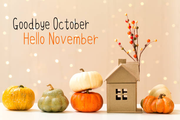 istock Goodbye October Hello November message with pumpkins with house 1180600739