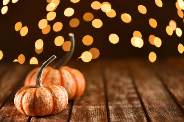 istock Thanksgiving still life with pumpkins and illuminated background on a rustic wooden table 1180601620