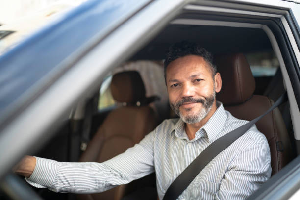 Portrait of businessman driving a car Portrait of businessman driving a car drivers seat stock pictures, royalty-free photos & images