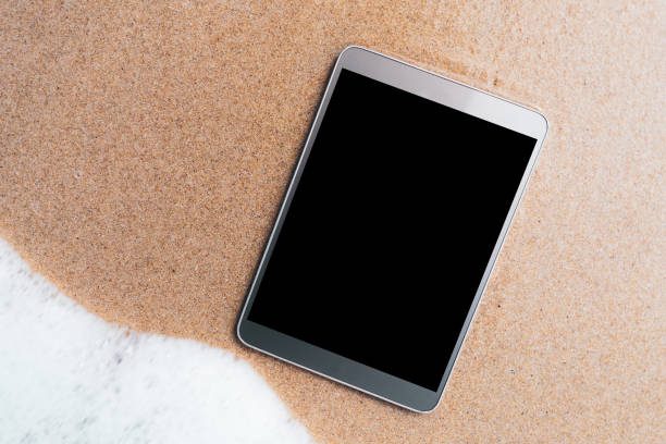 istock Smart phone on tropical sand beach texture background. 1180604545