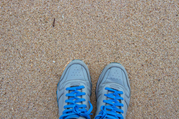 istock blue shoes on sand 1180605382