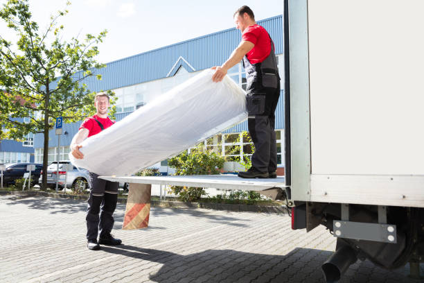 giovani che scaricano il materasso dal camion per strada - carry clothes foto e immagini stock