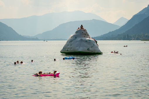 WORTHERSEE, AUSTRIA - AUGUST 07, 2018: People relax and float in the mountain lake.