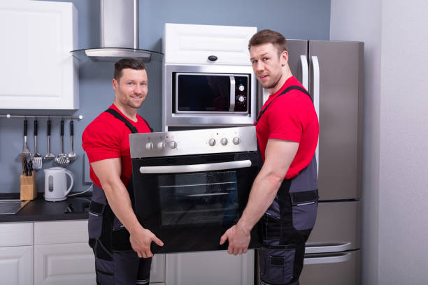 istock Young Male Worker Placing Modern Oven In Kitchen 1180607338