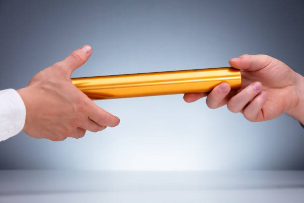 istock Man Passing The Baton To Partner 1180607471