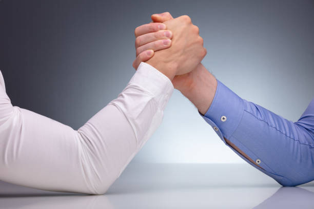 istock Two Businessmen Arm Wrestling 1180607476