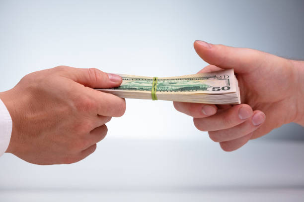 istock Close-up Of Two Male Hand's Holding Currency Bundle 1180607479