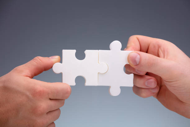 istock Two People Joining The Jigsaw Puzzles 1180607512
