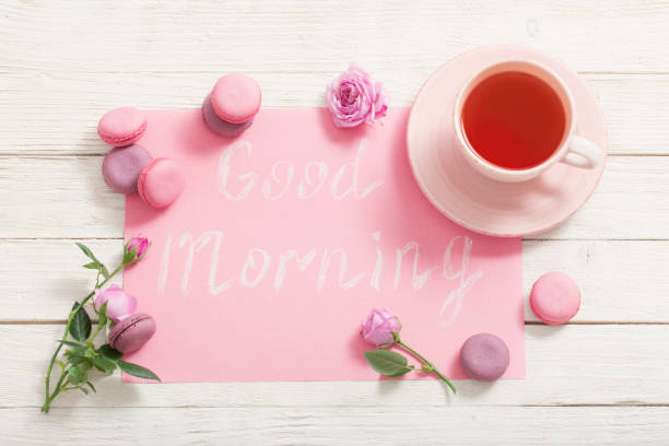 istock cup of tea and pink macaroons on white wooden table 1180609261