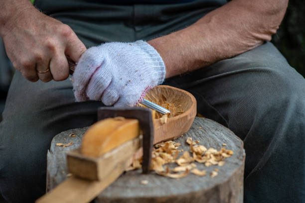 istock Craftsman demonstrates the process of making wooden spoons handmade using tools. National crafts concept. 1180609980