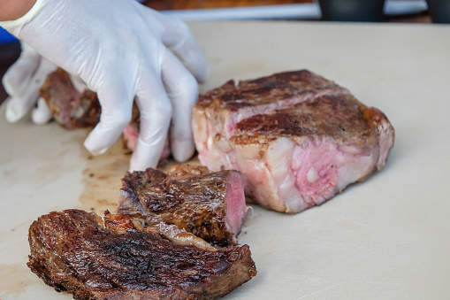 Close up males hand taking rib eye steak meat