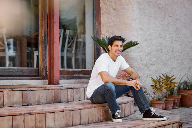 istock Smiling mature man sitting on steps at patio 1180611389