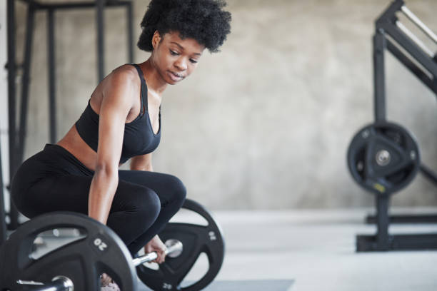 ejercicios de elevación. mujer afroamericana con el pelo rizado y con ropa deportiva tienen día de fitness en el gimnasio - gaining weight audio fotografías e imágenes de stock