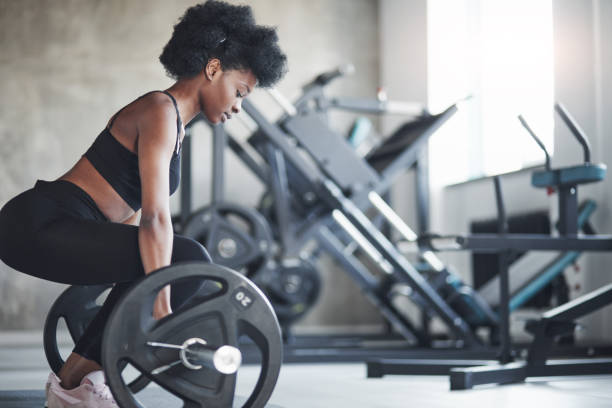 vista lateral. mujer afroamericana con el pelo rizado y con ropa deportiva tienen día de fitness en el gimnasio - gaining weight audio fotografías e imágenes de stock