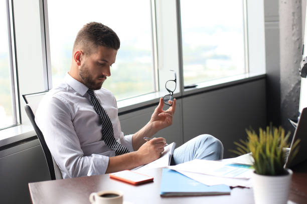 focused modern businessman working and taking notes in his modern office - 5908 imagens e fotografias de stock