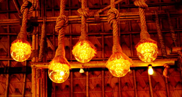 istock Hanging light bulbs over weathered wooden background 1180615366