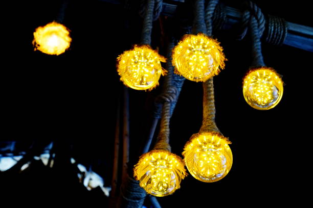 istock Hanging light bulbs over weathered wooden background 1180615373