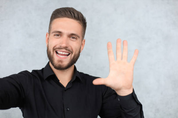 挨拶で手を挙げた笑顔の男の肖像。ハイファイブコンセプト - 6002 ストックフォトと画��像