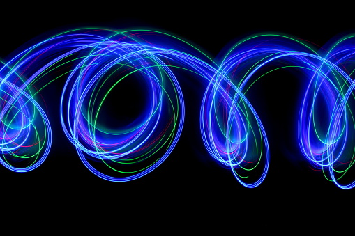 A light painting long exposure photo of fairy lights in a parallel lines pattern against a clean back background