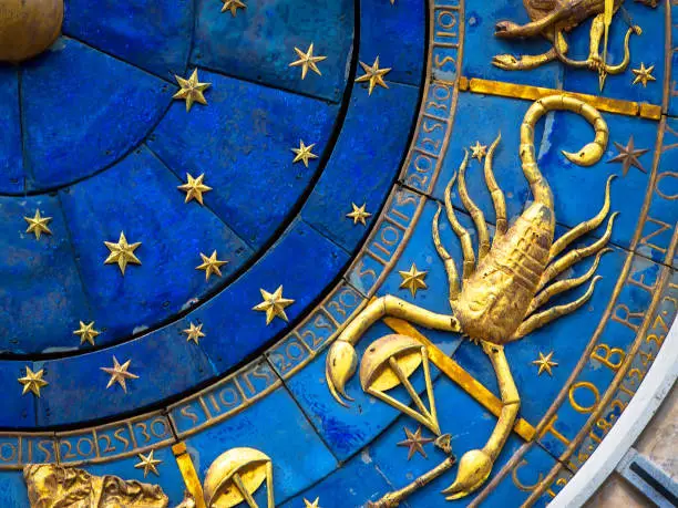 Scorpio astrological sign on ancient clock, medieval Torre dell’Orologio in Venice. Detail of Zodiac wheel with scorpion. Golden horoscope icon of scorpio closeup. Symbol of scorpion on star circle. Astrology concept.