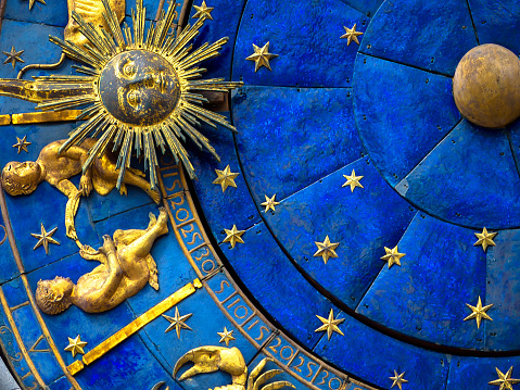 Gemini astrological sign on ancient clock, medieval Torre dell’Orologio in Venice. Detail of Zodiac wheel with Sun and Twins. Golden symbol of Gemini on star circle closeup. Concept of astrology and horoscope.