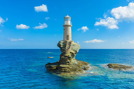 The beautiful Lighthouse Tourlitis of Chora in Andros island and a seagull, Cyclades, Greece