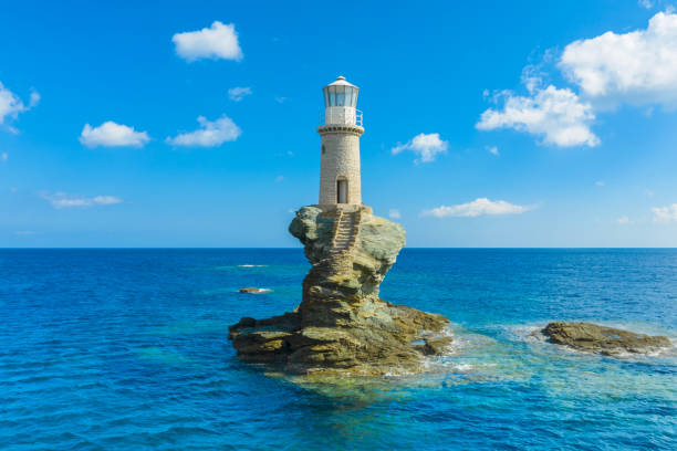 The beautiful Lighthouse Tourlitis of Chora in Andros island and a seagull, Cyclades, Greece The beautiful Lighthouse Tourlitis of Chora in Andros island and a seagull andros island stock pictures, royalty-free photos & images