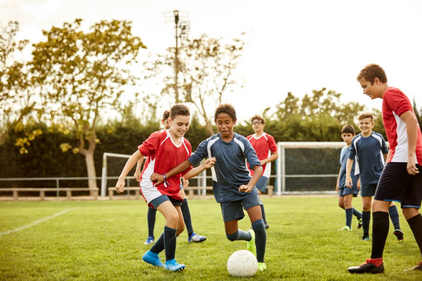 Boys playing soccer match on training ground
