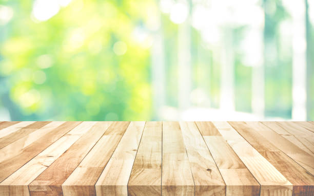 istock Empty wood table top on blur abstract green garden from window view background 1180622783