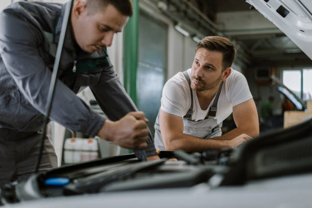istock Auto mechanics examining a car engine in a repair shop 1180623128