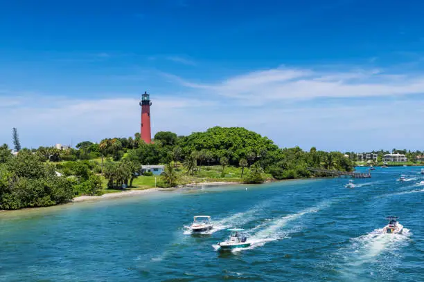 Beautiful view of the West Palm Beach County with speedboats and Jupiter lighthouse at sunny summer day, Florida