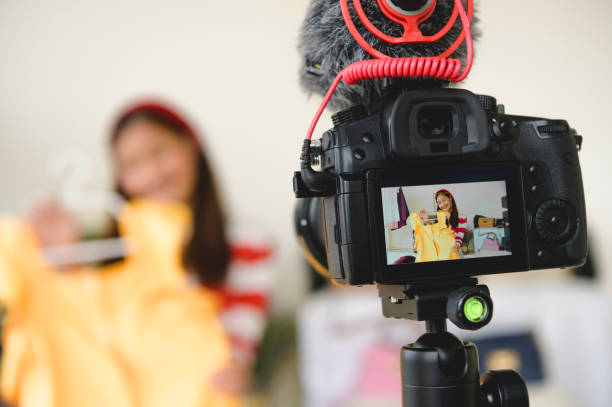 istock Professional DSLR digital camera film video live with vlogger blogger interview background. Woman coaching trading and review clothing product. Business presentation training class. People lifestyle 1180631240
