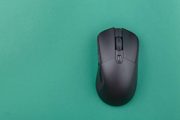 istock black wireless computer mouse on a green background. modern office equipment. 1180632378