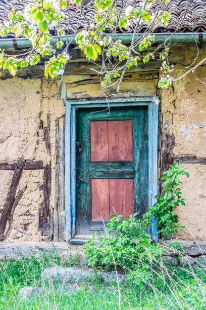 Wooden door of old typical abandoned wattle and daub house at the Vitosha Mountain village of Chuypetlovo, Bulgaria, exterior partial view