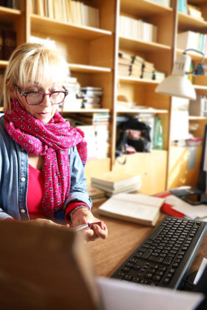 istock Senior woman Librarian cataloging books 1180633716
