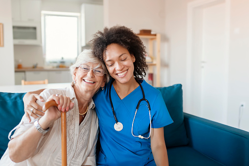 Portrait of Smiling Senior Woman and Her Mixed Race Female Caregiver Together at Nursing Home. Caring Female Doctor Taking Care of a Happy, Elderly Woman