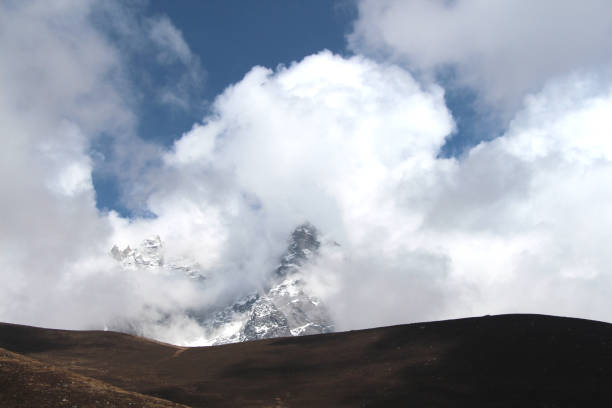istock Mountain peak is visible through dense white clouds in Himalayas 1180635528