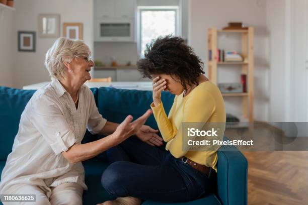 Older Mother Comforting Sad Adult Adopted Mixed Race Grown Daughter Stock Photo - Download Image Now