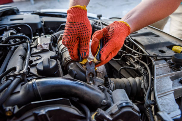 istock Hands in gloves with car engine close up 1180638029