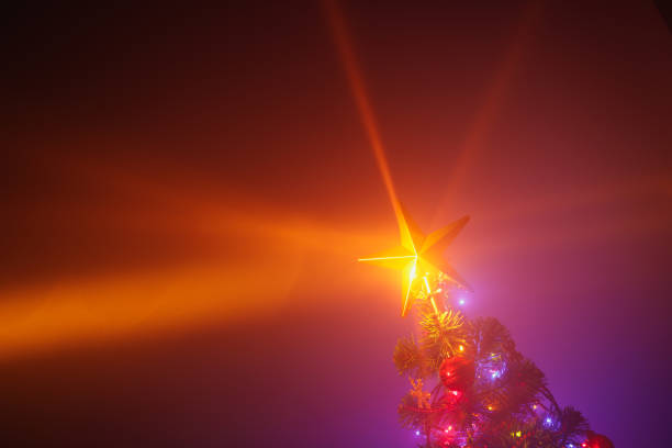 istock Christmas tree with festive lights, purple background 1180638268